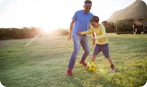 Vader en zoon die voetbal spelen