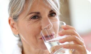 Vrouw die een glas water  drinkt