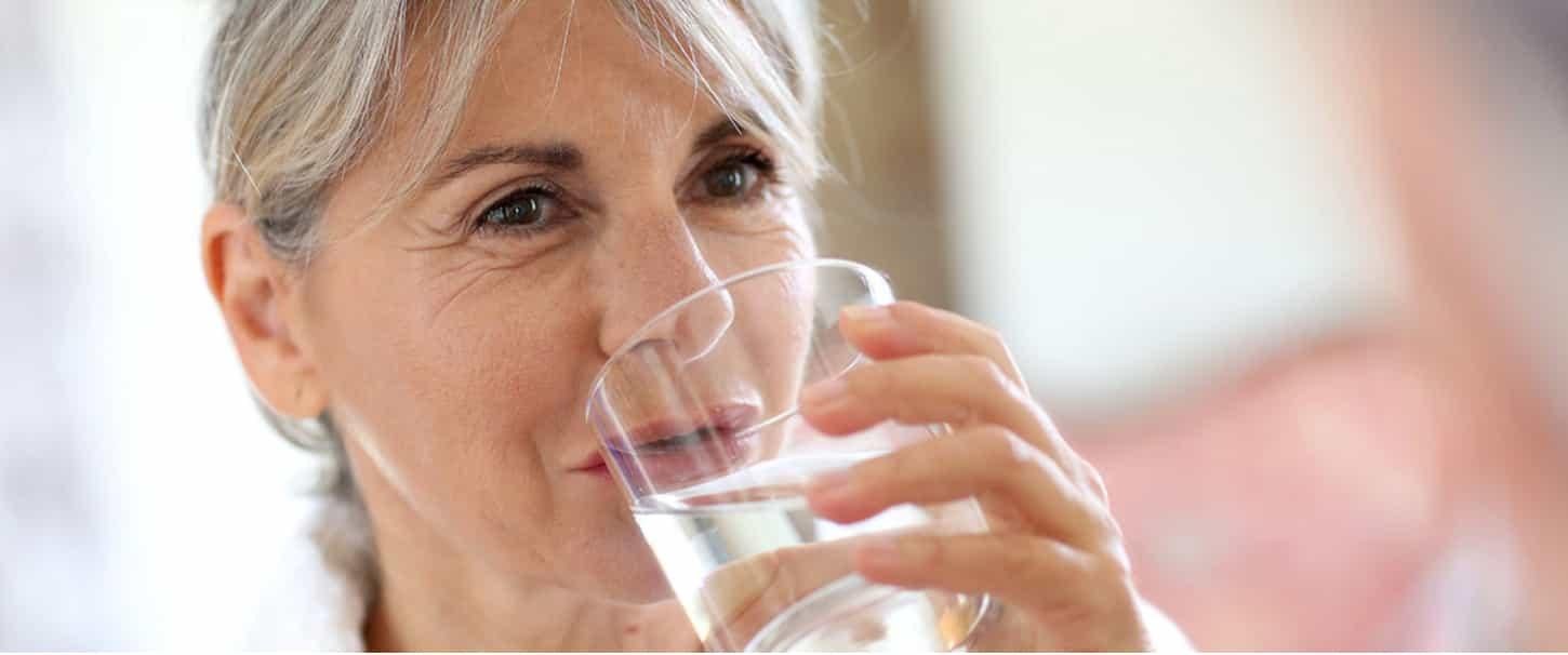 Vrouw die een glas water drinkt