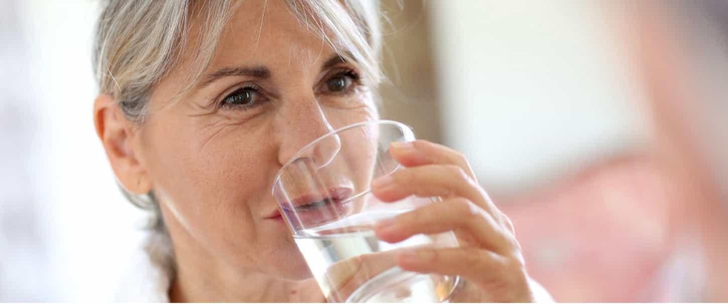 Vrouw die een glas water  drinkt